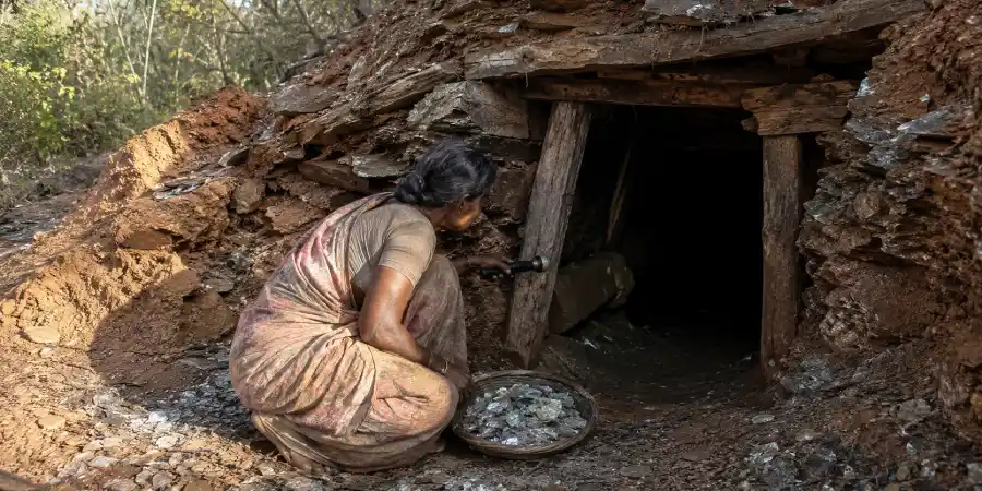 बंद पड़ी अभ्रक खदान का सँकरा मुहाना और भीतर जाती अँधेरी सुरंग पर पड़ती टॉर्च की रोशनी