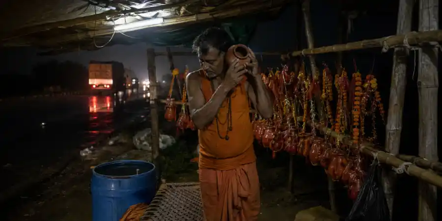 सावन की रात में हाईवे के किनारे काँवड़ का स्टैंड, टँगी हुई काँवड़ें और उनके घड़े