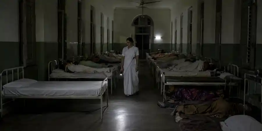 अस्पताल के वार्ड में क़तार से लगे बिस्तर और उनमें से एक जिस पर चादर बिलकुल कसी हुई है